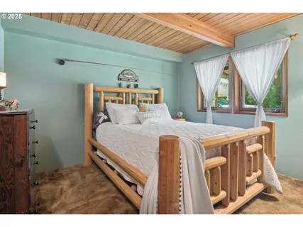 a bedroom with a bed a mirror and a large window