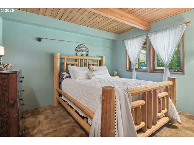 a bedroom with a bed a mirror and a large window