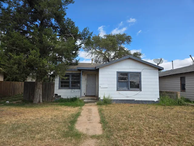 a front view of house with yard and trees around