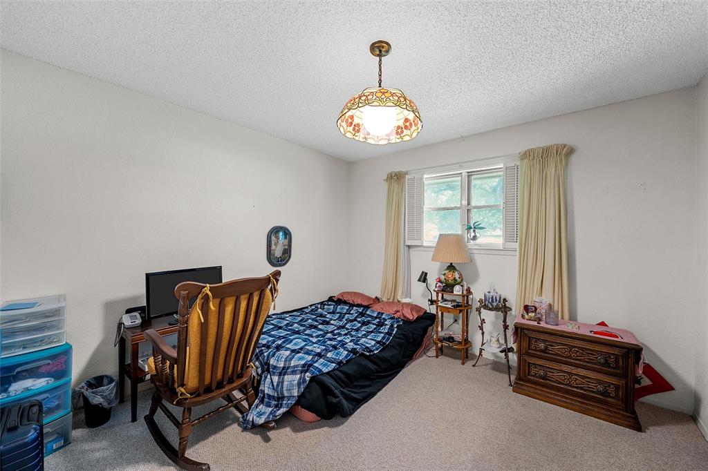 219 Opal Street Hewitt, TX 76643 - Photo 21 of 28 a bedroom with a bed and a chandelier
