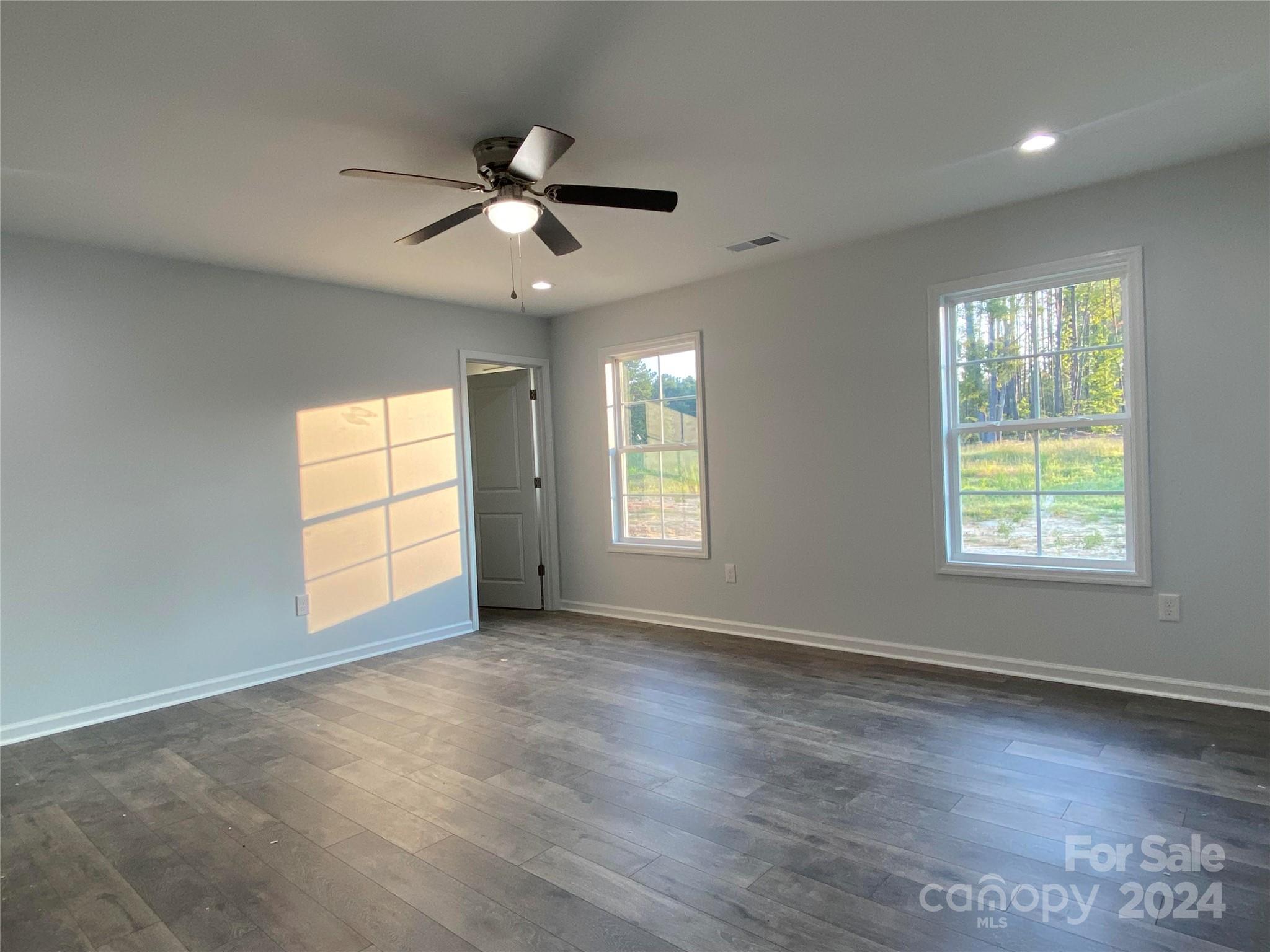 782 Starcliff Circle Lancaster, SC 29720 - Photo 6 of 8 an empty room with wooden floor fan and windows