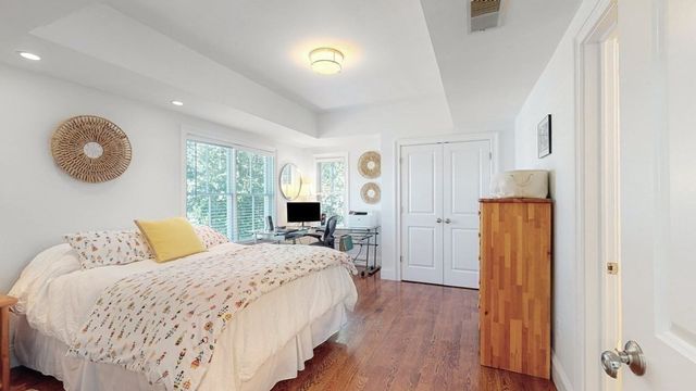 a bedroom with a bed and wooden floor
