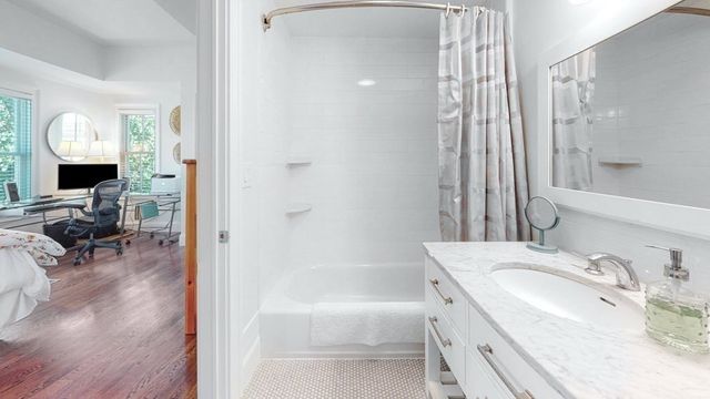a bathroom with a tub sink and mirror