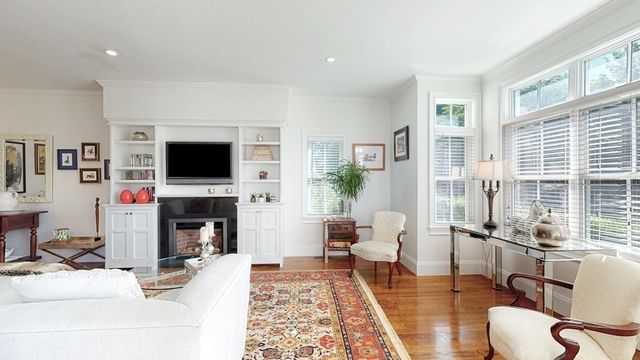 a living room with furniture a flat screen tv and a fireplace