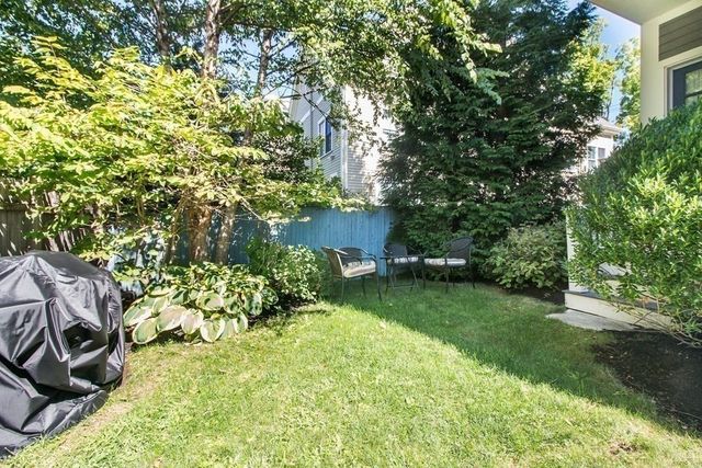 a view of backyard with table and chairs and potted plants