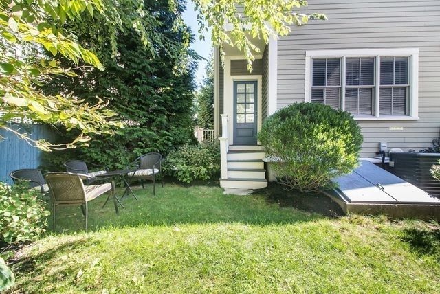 a view of a chair and table in backyard of the house
