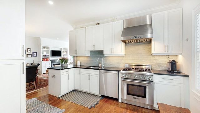 a kitchen with stainless steel appliances a sink stove and cabinets