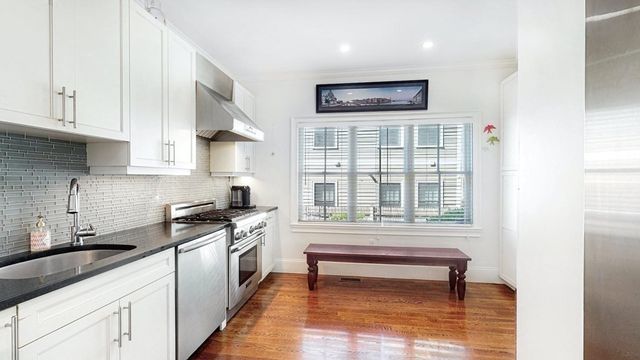 a kitchen with stainless steel appliances granite countertop a stove a sink and a microwave