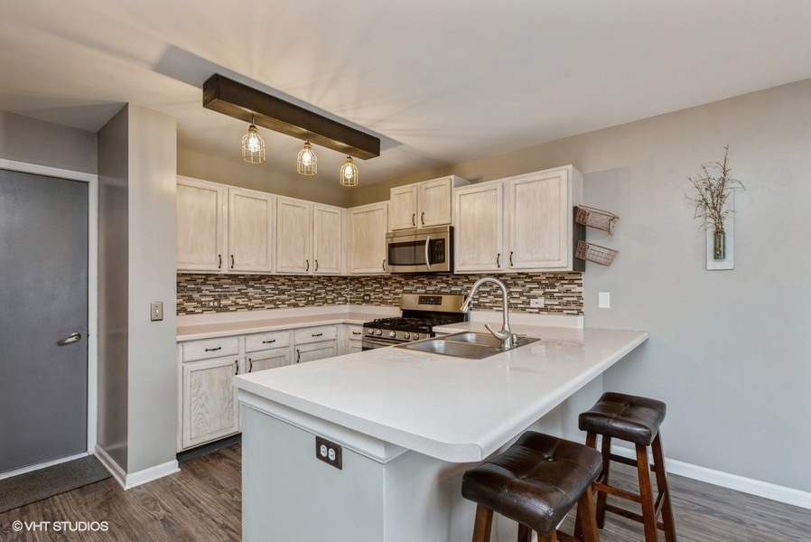 215 Rainier Way Fox Lake, IL 60020 - Photo 5 of 15 a kitchen with a sink a stove and chairs