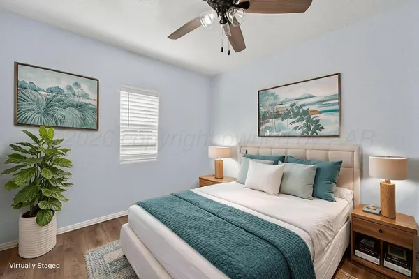 a bedroom with bed plant and a window