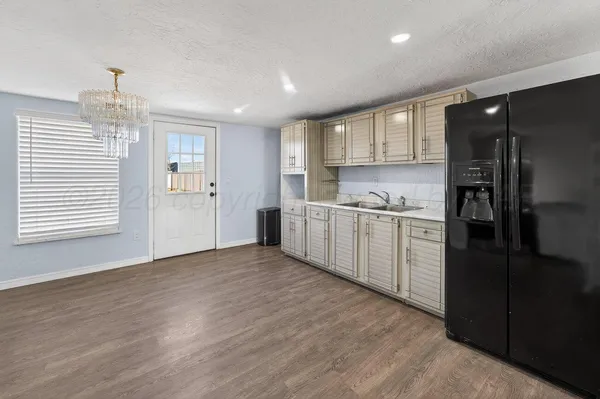 a view of a kitchen with a sink and dishwasher refrigerator freezer
