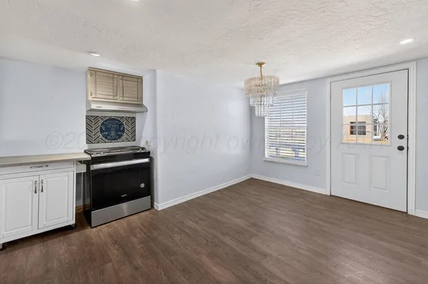 an empty room with windows and fireplace