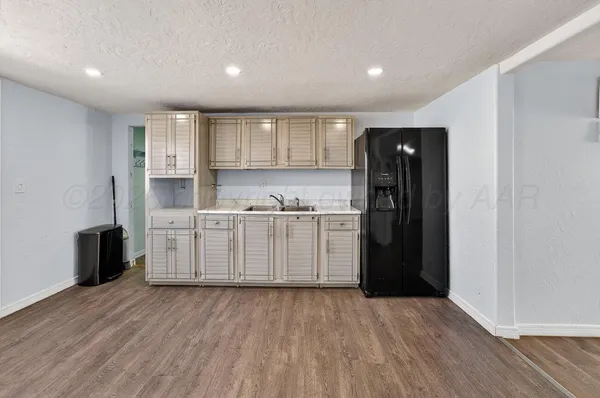 a kitchen with kitchen island white cabinets and refrigerator