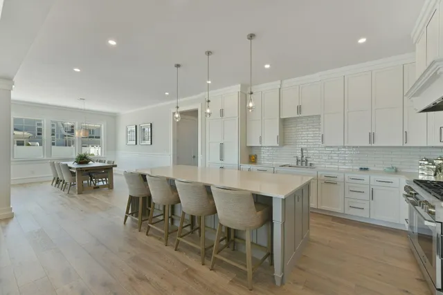 a kitchen with a sink chairs and white appliances