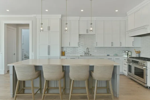 a kitchen with stainless steel appliances granite countertop a table chairs sink and cabinets