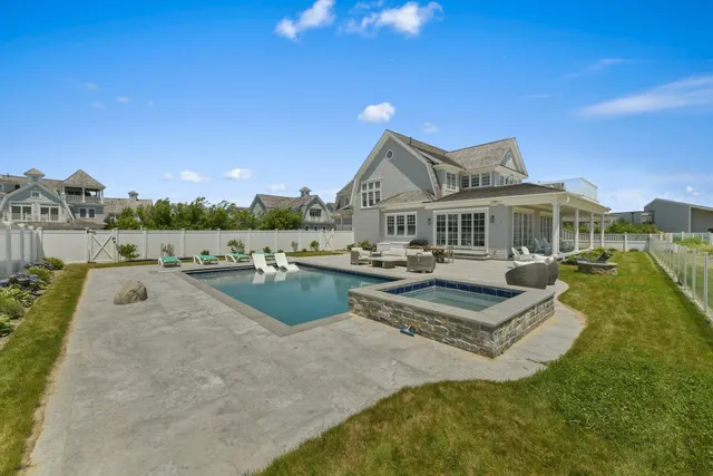 a view of a house with pool and chairs