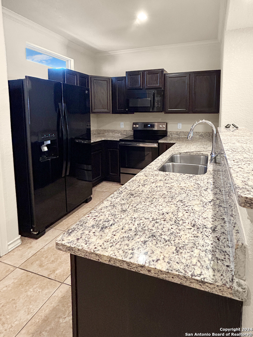 14006 Fratelli Road, Unit 103 San Antonio, TX 78233 - Photo 11 of 16 a kitchen with granite countertop wooden cabinets and granite counter tops