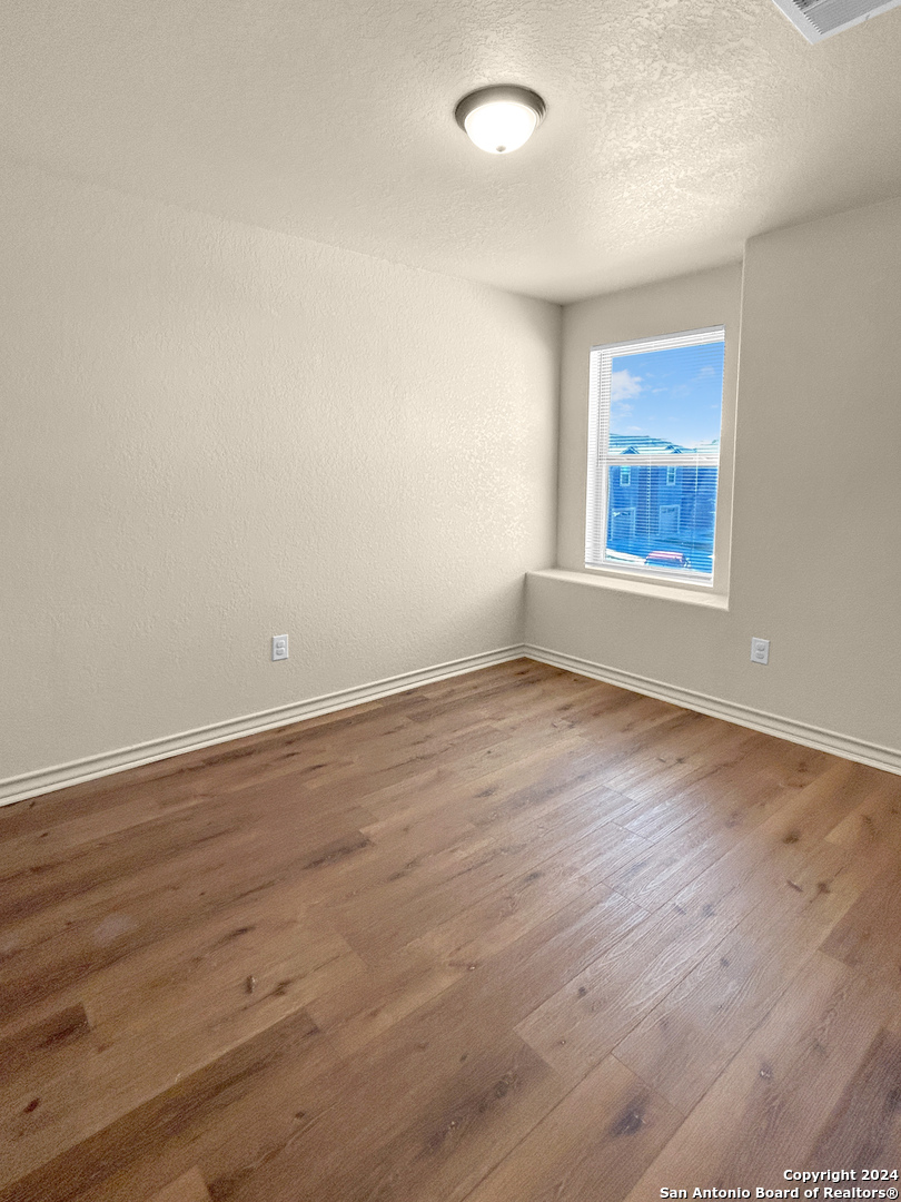 14006 Fratelli Road, Unit 103 San Antonio, TX 78233 - Photo 12 of 16 wooden floor in an empty room with a window