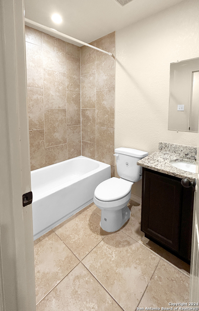 14006 Fratelli Road, Unit 103 San Antonio, TX 78233 - Photo 13 of 16 a bathroom with a granite countertop sink a toilet and shower