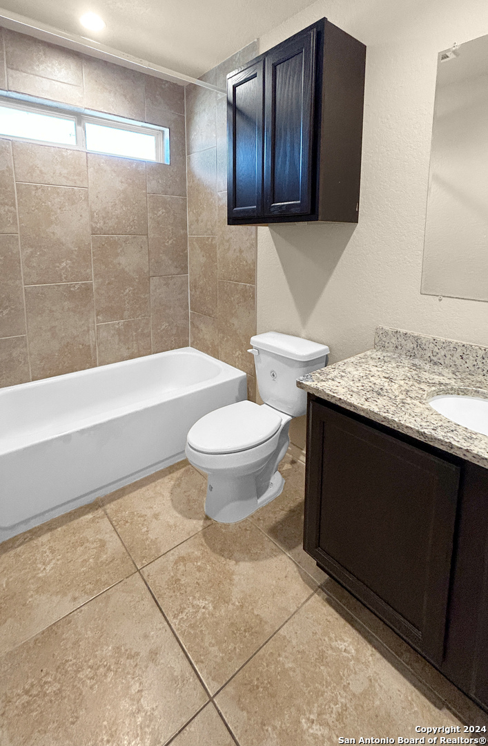 14006 Fratelli Road, Unit 103 San Antonio, TX 78233 - Photo 8 of 16 a bathroom with a granite countertop toilet a sink and bathtub