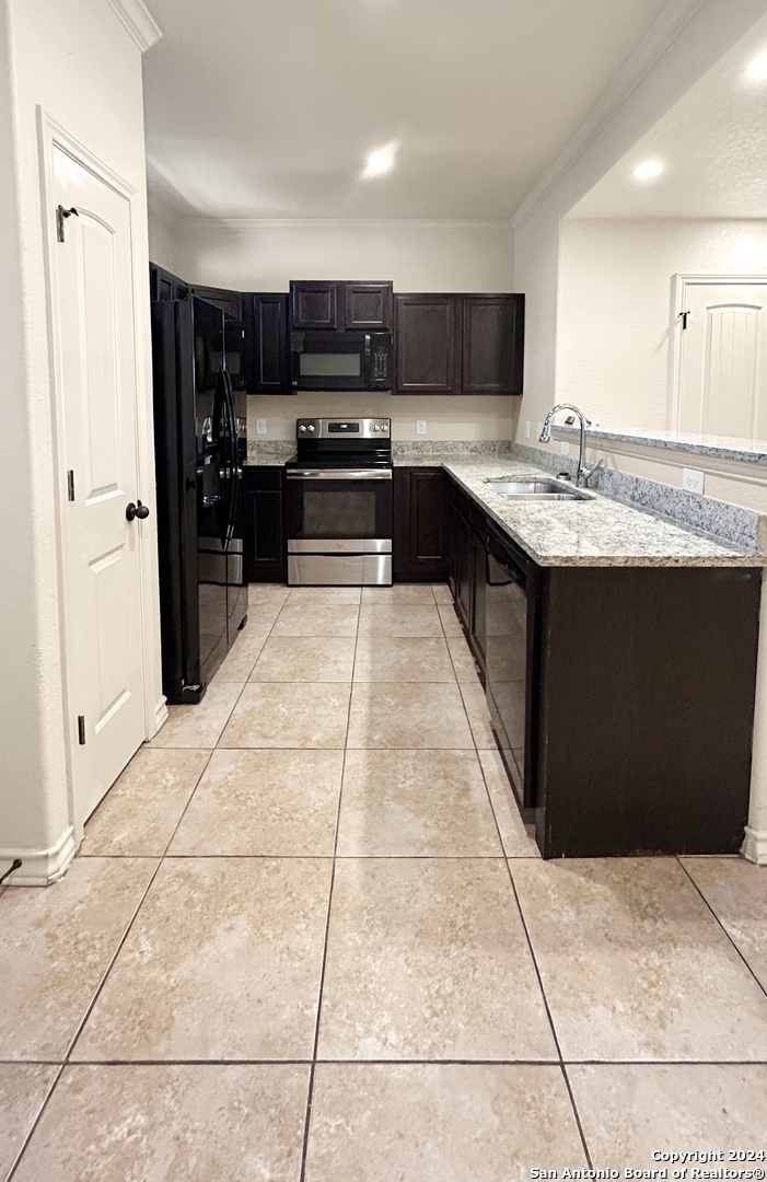 14006 Fratelli Road, Unit 103 San Antonio, TX 78233 - Photo 10 of 16 a kitchen with stainless steel appliances kitchen island granite countertop a refrigerator and a sink