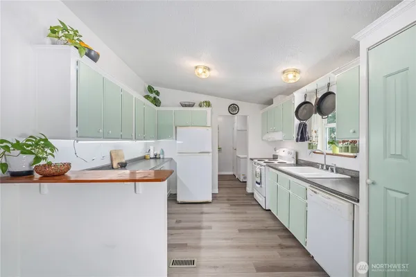 a large kitchen with a sink and refrigerator
