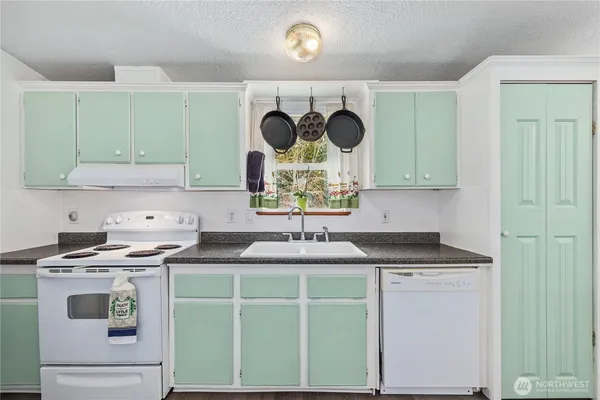 a kitchen with kitchen island granite countertop a sink and a stove