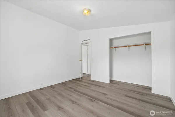 an empty room with wooden floor and window