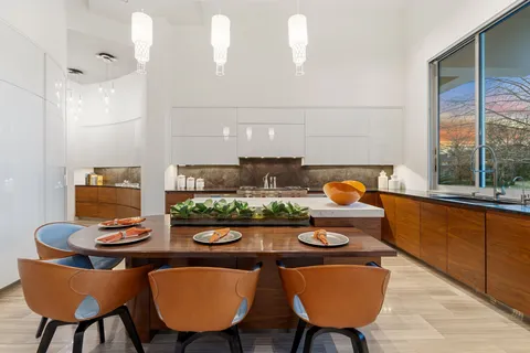 a view of a dining room with furniture a rug and wooden floor