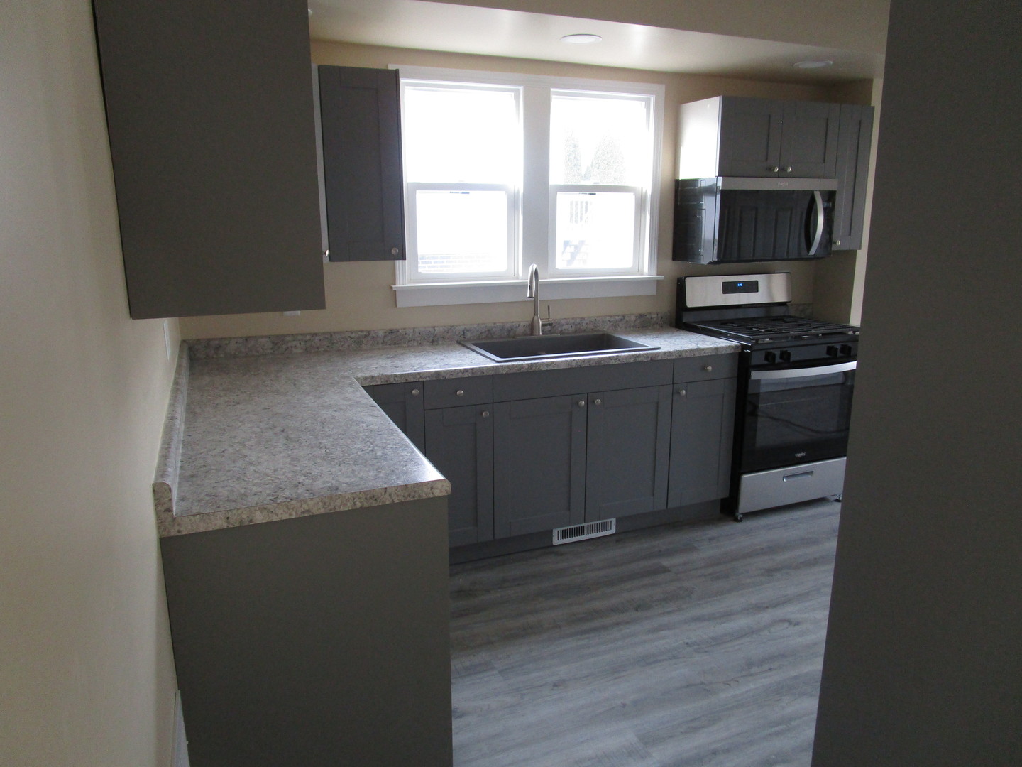 403 West Washington Street Harvard, IL 60033 - Photo 4 of 13 a kitchen with a stove a sink and a microwave