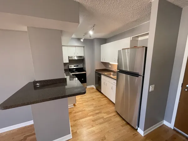 a kitchen with granite countertop a refrigerator and a sink