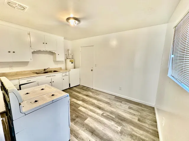 a view of a kitchen with refrigerator and white cabinets