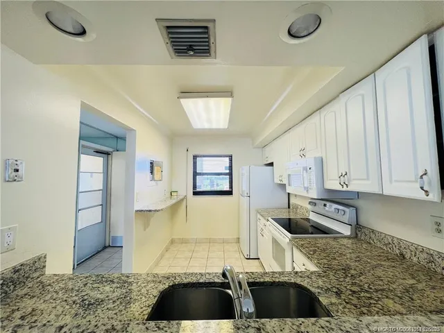 a kitchen with white cabinets sink and white appliances
