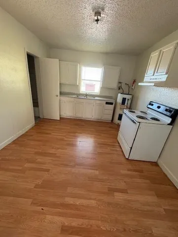 a view of a kitchen with wooden floor and electronic appliances