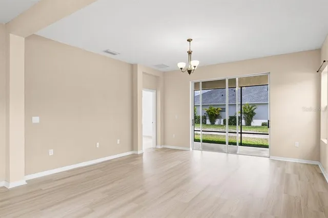 an empty room with wooden floor and door