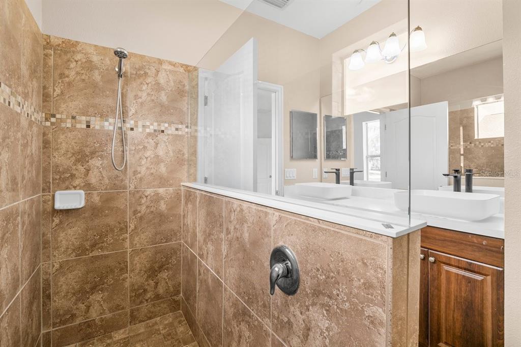 11790 Fennemore Way Parrish, FL 34219 - Photo 14 of 41 a bathroom with a granite countertop sink a mirror and shower