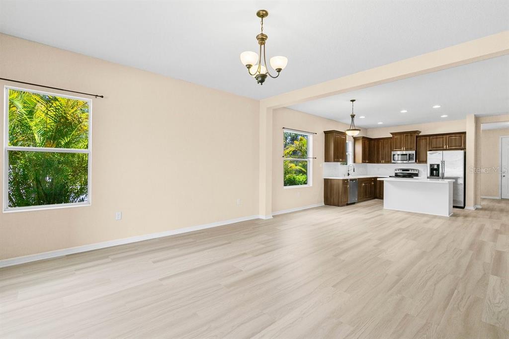 11790 Fennemore Way Parrish, FL 34219 - Photo 16 of 41 a view of a big room with wooden floor a kitchen view and windows