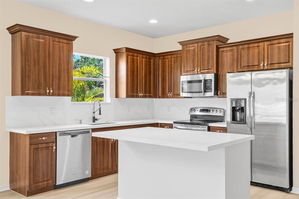 11790 Fennemore Way Parrish, FL 34219 - Photo 8 of 41 a kitchen with stainless steel appliances granite countertop a refrigerator sink and cabinets