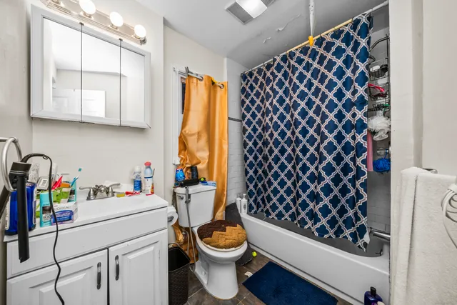 a bathroom with a sink a toilet and a shower curtain