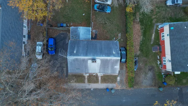 an aerial view of a house with swimming pool and large trees