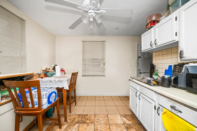 a kitchen with stainless steel appliances granite countertop a sink a stove a dining table and chairs with wooden floor