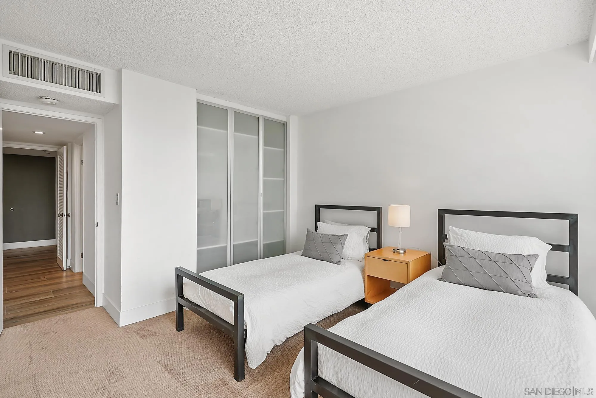 1720 Avenida Del Mundo, Unit 208 Coronado, CA 92118 - Photo 21 of 42 a bedroom with two beds and painted walls