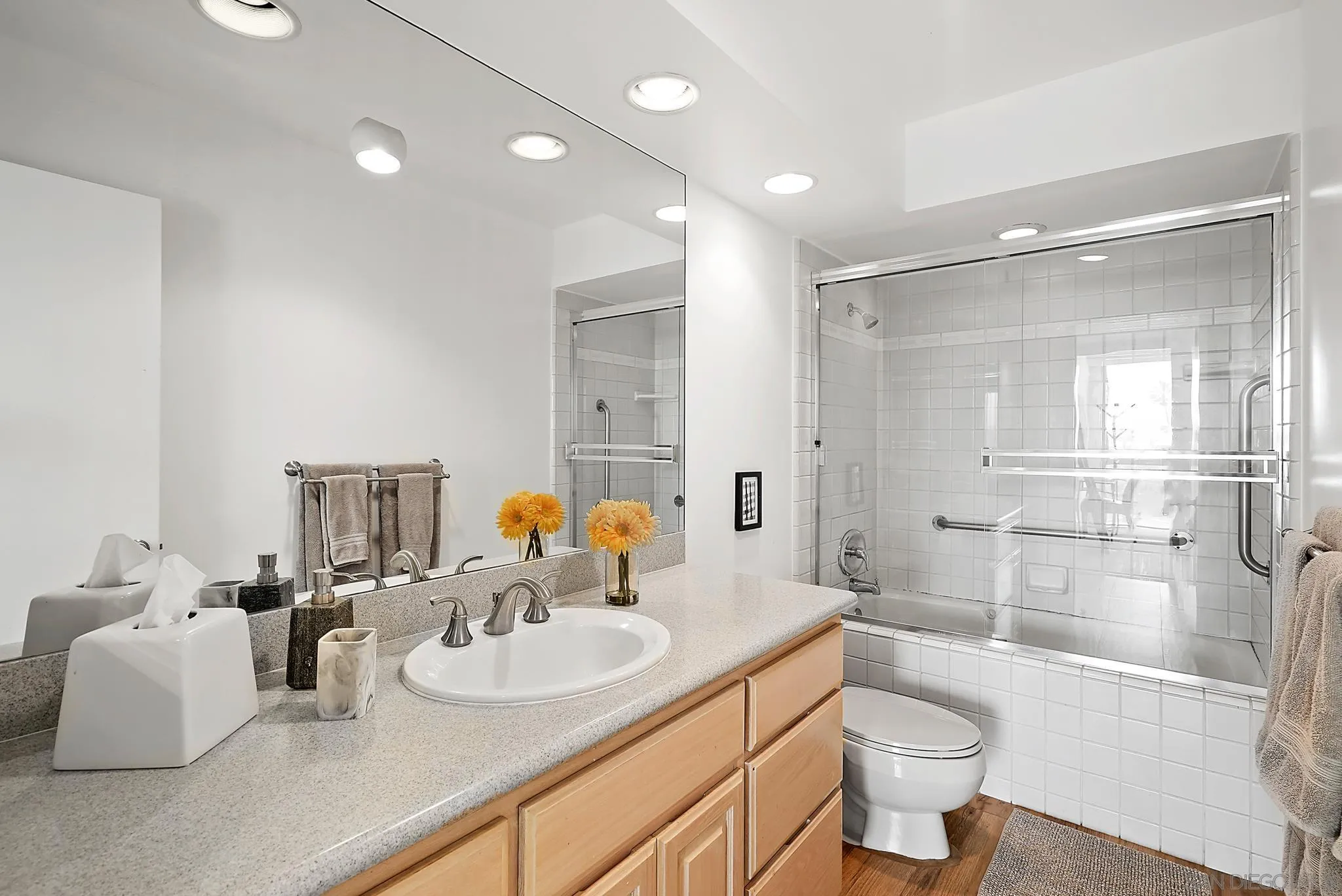 1720 Avenida Del Mundo, Unit 208 Coronado, CA 92118 - Photo 25 of 42 a bathroom with a double vanity sink toilet mirror and shower