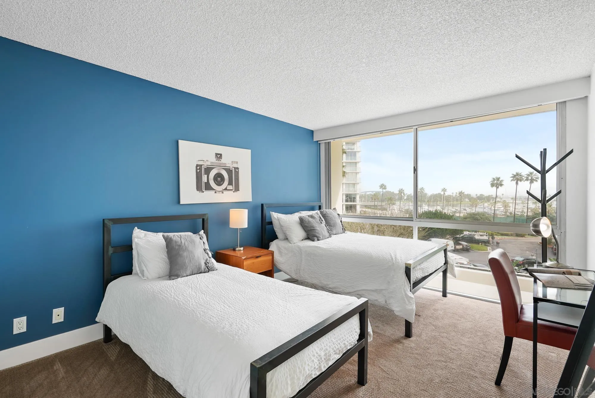 1720 Avenida Del Mundo, Unit 208 Coronado, CA 92118 - Photo 26 of 42 a bedroom with two beds and a large window