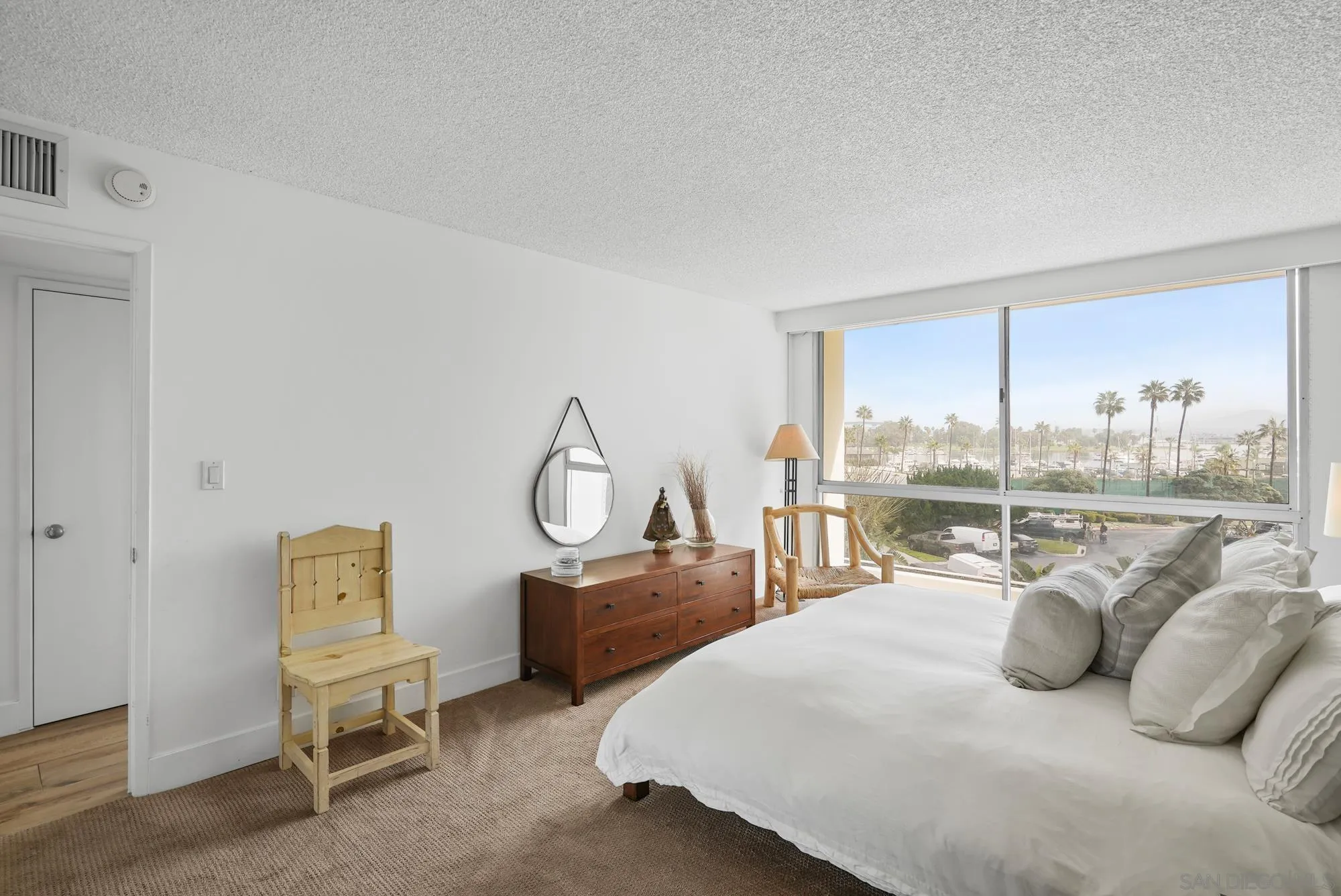 1720 Avenida Del Mundo, Unit 208 Coronado, CA 92118 - Photo 30 of 42 a bedroom with a bed and a large window