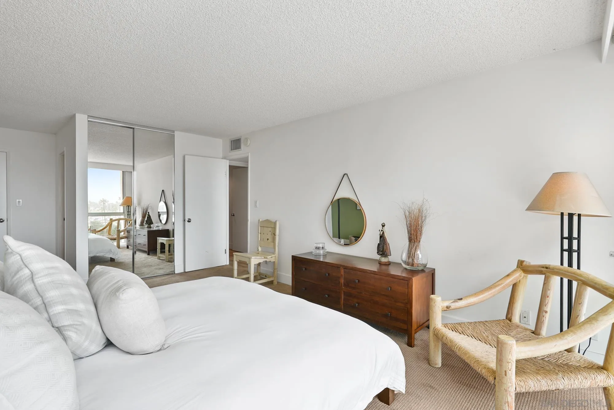 1720 Avenida Del Mundo, Unit 208 Coronado, CA 92118 - Photo 31 of 42 a bedroom with a bed and a chair
