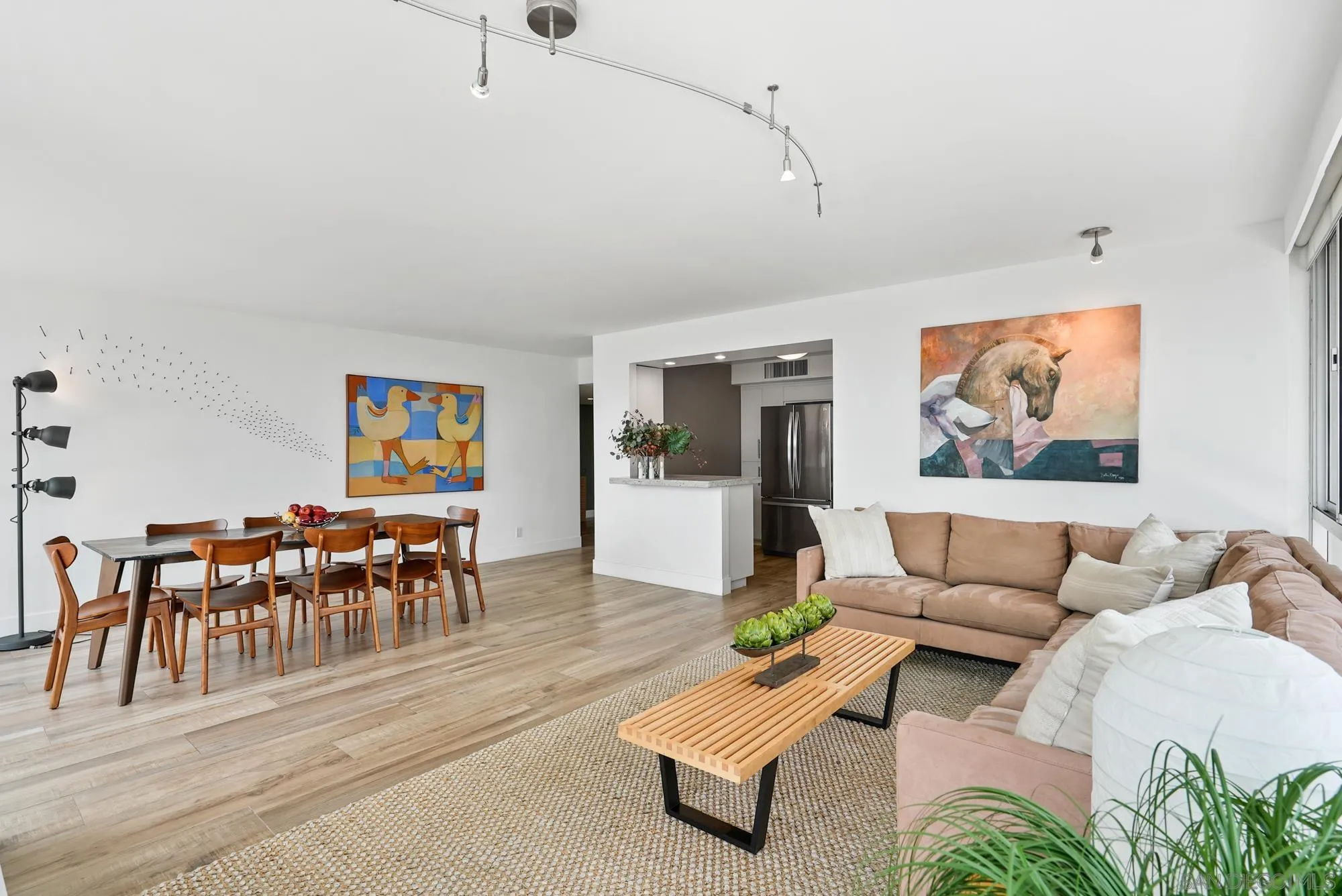 1720 Avenida Del Mundo, Unit 208 Coronado, CA 92118 - Photo 4 of 42 a living room with furniture and a dining table with wooden floor