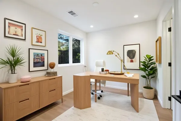a view of a workspace with furniture and window