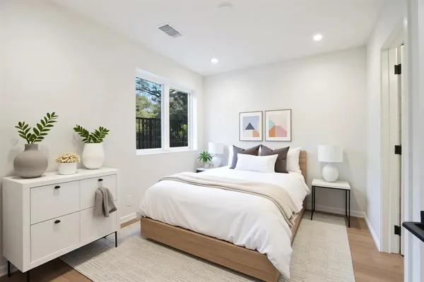 a bedroom with a large bed and a potted plant
