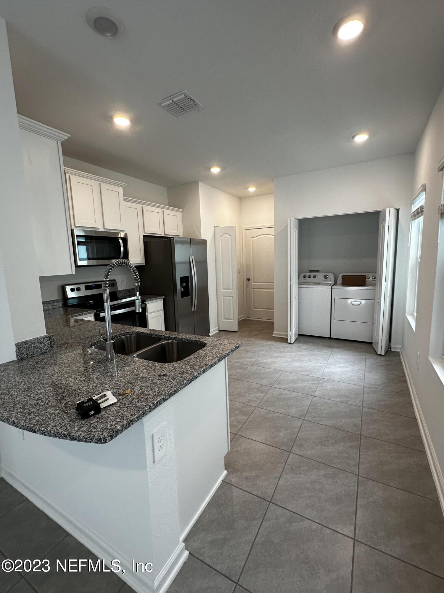 409 Talulla Trail St. Augustine, FL 32095 - Photo 26 of 58 a kitchen with stainless steel appliances granite countertop a sink a stove and a refrigerator